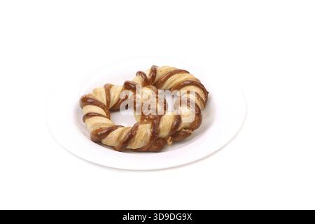 Biscotti a forma di nodo in un piatto bianco. Primo piano Foto Stock