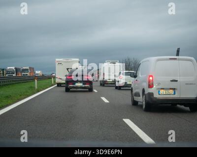 Brescia, Italia 21 novembre 2025 veicoli in coda lungo l'autostrada A21 in Lombardia, Italia durante una giornata invernale piovosa, con conseguente rallentamento del traffico e Foto Stock