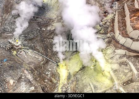 Un campo di fumarole attivo con estesi depositi di zolfo nel cratere di Owakudani, Hakone, Kanagawa, Giappone. Il terreno giallo zolfo indica l'alta concentrazione di vapori di zolfo; a sinistra si trova una delle stazioni di monitoraggio del vapore con un collegamento a tubo. L'area è nota per le sue sorgenti termali sulfuree, in cui si cuociono i tradizionali kuro-tamago (uova nere) Foto Stock