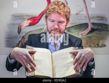 Londra, Regno Unito. 5 dicembre 2025. Il personale di Christie con un raro libro evangelico del X secolo legato ad uno scriptorium femminile. Stima: £700.000-1.000.000. La promozione Christie's Valuable Books & Manuscripts, parte della Classic Week, si terrà il 10 dicembre 2025. Crediti: Imageplotter/Alamy Live News Foto Stock