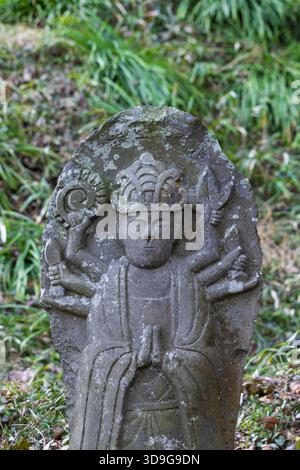 Piccola targa di scultura di Buddha con la figura di Murti, diversi volti e braccia che simboleggiano diversi poteri nel tempio Saigandenji nel piccolo villaggio di Aso Kumamoto perfezionamento in Giappone Foto Stock