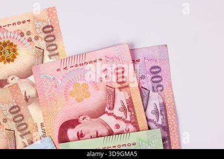 Varie banconote thailandesi da 1000 e 500 baht posizionate insieme mostrando i loro colori e disegni in luce naturale. Foto Stock