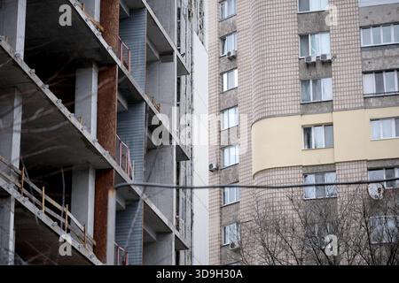 La nuova costruzione sorge accanto ad un vecchio blocco di appartamenti in un paesaggio urbano. Foto Stock