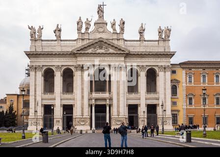 Vista frontale della facciata principale barocca dell'arcibasilica di San Giovanni in Laterano, con le statue di Cristo, San Giovanni Battista e San Giovanni Evan Foto Stock