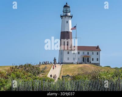 Faro di Montauk Point con i visitatori in un chiaro pomeriggio estivo a Montauk, Long Island, New York, un punto di riferimento storico sulla punta orientale dell'isola. Foto Stock