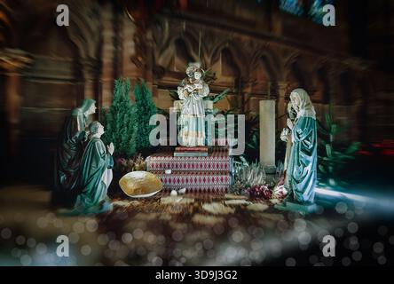 Statua di Maria e altre tre statue del presepe. La scena è ambientata in una chiesa. Natività di Gesù scena con la Sacra famiglia Foto Stock