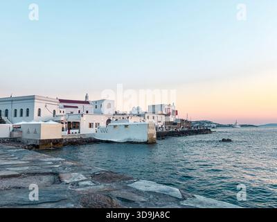 La piccola venezia di Mykonos al tramonto, le case delle cicladi bianche che costeggiano il tranquillo lungomare dell'egeo, il romantico skyline dell'ora blu e il fascino tranquillo dell'isola Foto Stock