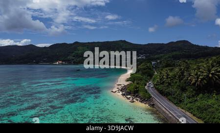 Paradiso dell'isola incontaminata: La fitta giungla tropicale e le palme si incontrano in un incontaminato litorale sabbioso Foto Stock
