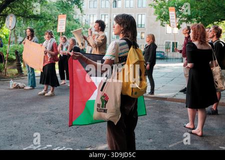 I manifestanti tengono segni e bandiere durante una pacifica manifestazione pro-Palestina nel parco dell'Autonomia vicino all'Università di Varsavia. Foto Stock