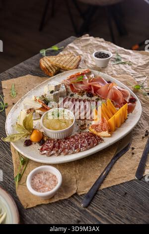 Salumi di lusso con carni gourmet, vari formaggi e conserve di frutta per un aperitivo festivo Foto Stock