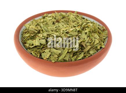 Tagliare il dragoncello in una piccola ciotola di terracotta isolata su uno sfondo bianco con vista laterale. Foto Stock