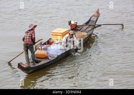 Fiume Tonle SAP, Cambogia. 6 dicembre 2025. I pescatori cambogiani praticano la pesca a rete dalle tradizionali barche in legno sul fiume Tonle SAP, approfittando della migrazione stagionale del pesce mentre il lago continua a defluire verso il fiume Mekong a seguito dell'inversione annuale del flusso all'inizio di ottobre. Durante questo periodo di deflusso, un gran numero di piccole specie di acqua dolce si spostano a valle in scuole dense. Questo raro fenomeno idrologico crea le condizioni ideali per le comunità di pescatori locali che si affidano pesantemente a questa stagione per la raccolta di pesci d'acqua dolce. Crediti: Kevin Izorce/Alamy Live News Foto Stock