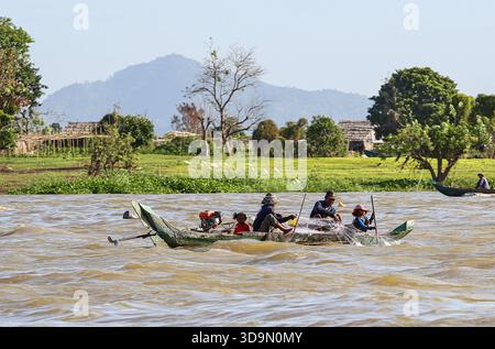 Fiume Tonle SAP, Cambogia. 6 dicembre 2025. I pescatori cambogiani recuperano le reti dalle tradizionali barche in legno sul fiume Tonle SAP, approfittando della migrazione stagionale del pesce mentre il lago continua a defluire verso il fiume Mekong a seguito dell'inversione annuale del flusso all'inizio di ottobre. Durante questo periodo di deflusso, un gran numero di piccole specie di acqua dolce si spostano a valle in scuole dense. Questo raro fenomeno idrologico crea le condizioni ideali per le comunità di pescatori locali che si affidano pesantemente a questa stagione per la raccolta di pesci d'acqua dolce. Crediti: Kevin Izorce/Alamy Live News Foto Stock
