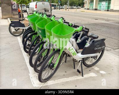 Denver, Colorado, USA - 4 giugno 2025: Biciclette elettriche del sistema di condivisione biciclette Lime Bike lasciate incustodite su un marciapiede nel centro di Denver. Foto Stock