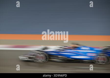 Le auto veloci si muovono rapidamente in pista al Gran Premio del Qatar di Formula 1 2025 in Qatar durante la sessione serale della gara Foto Stock