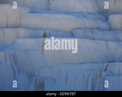 Un primo piano astratto dei depositi di carbonato di calcio bianco liscio e stratificato alle Mammoth Hot Springs di Yellowstone. Foto Stock