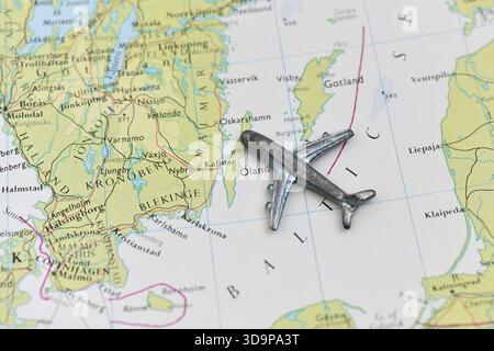 Un piccolo aeroplano giocattolo metallico poggia su una mappa dettagliata, che indica il viaggio aereo o la logistica attraverso il Mar Baltico e la costa svedese (Kalmar). Foto Stock