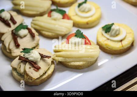 Panini a vista Belegte Brotli con pollo, uova e asparagi su un piatto da portata bianco in vendita in una panetteria di Zurigo, Svizzera Foto Stock