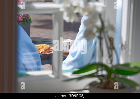 Potrai approfittare della vista da una finestra per due persone che gusteranno la colazione a base di waffle e caffè. Foto Stock