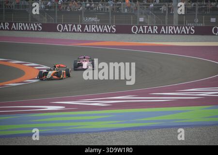 Le auto gareggiano nel Gran Premio del Qatar al circuito internazionale di Losail durante la stagione 2025 con tifosi che tifosi a bordo campo. Foto Stock