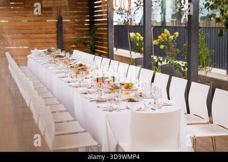 Ampio tavolo in terrazza con vista sulla città - elegante disposizione dei tavoli per eventi Foto Stock