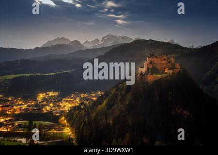 Vista notturna del castello Hohenwerfen illuminato sulla collina e della città di Werfen sotto di essa Foto Stock