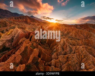 Vista aerea del tramonto panoramico sul Fairy tale Canyon o Skazka Canyon con cresta di arenaria rossa e aspra montagna in Kirghizistan Foto Stock