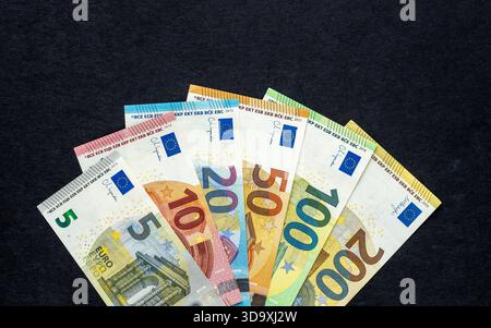 Denaro in euro. Tutte le banconote cartacee del paese dell'Unione europea. Valuta della zona euro. disposti su un ventilatore su sfondo nero. Concetto di business finanziario. Foto Stock