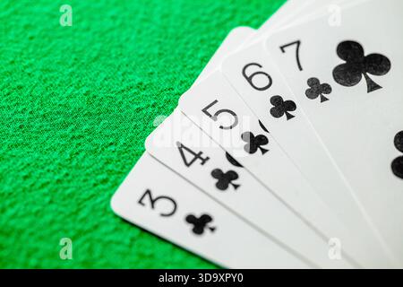 disposizione delle carte nel poker dritto a filo, quinto dei club da tre a sette, focus selettivo Foto Stock