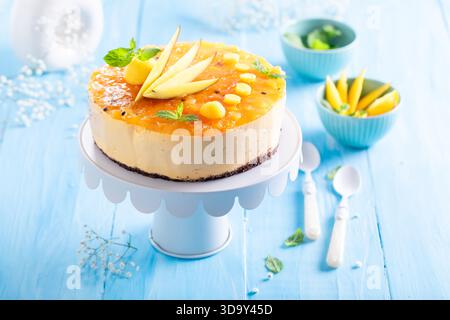 Dolce cheesecake al mango servito su un tavolo di legno. Cheesecake al mango con vaniglia e frutta. Foto Stock