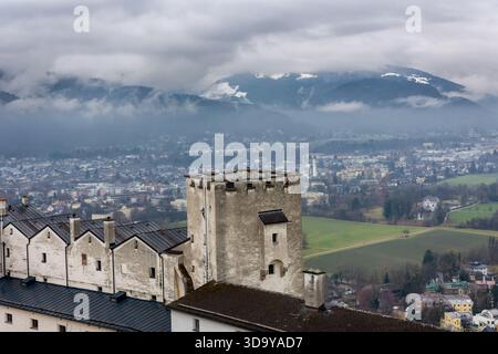 La storica torre della fortezza si affaccia sulla città di Salisburgo e sulle cime alpine innevate Foto Stock
