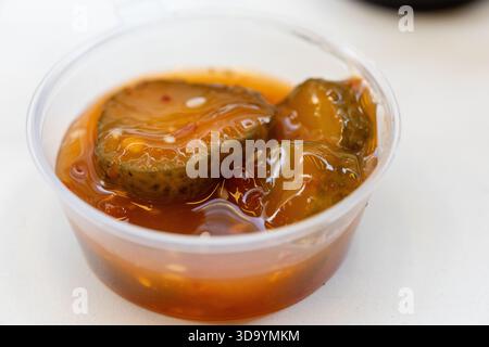 Primo piano di kimchi tradizionali coreani fermentati in una piccola ciotola di plastica Foto Stock
