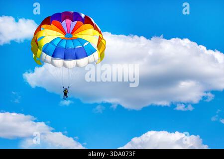 Parapendio con paracadute sullo sfondo di cielo nuvoloso blu. Foto Stock