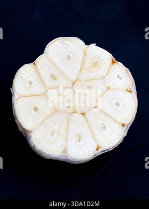 Immagine ravvicinata di un bulbo d'aglio fresco tagliato a metà, che mostra la struttura pulita e dettagliata dei suoi chiodi di garofano. T Foto Stock