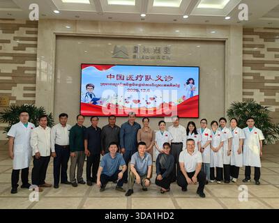 Il governatore della provincia di Koh Kong della Cambogia Chhy va (ultima fila, ottavo da sinistra) posa per una foto di gruppo con il team medico cinese che aiuta la Cambogia e l'alta dirigenza di Tatai Hydropower Co., Ltd. Dopo la clinica gratuita.​ provincia di Guogong, Cambogia.6 dicembre 2025. Il quarto lotto della squadra medica cinese che ha aiutato i servizi di medicina tradizionale cinese della Cambogia, in collaborazione con China Heavy Machinery Cambodia Tatai Hydropower Co., Ltd., ha svolto congiuntamente un'attività di consultazione medica gratuita su larga scala nella provincia di Kratie, fornendo "servizi medici porta a porta" per l'emplo sino-cambogiano Foto Stock