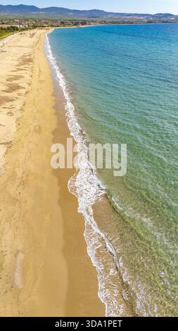 Vista aerea con droni sulla spiaggia di Kalyves in Calcidica, Grecia. Acque turchesi cristalline, costa sabbiosa e dolci onde lungo la costa mediterranea. Idil Foto Stock