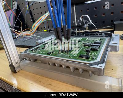 Roma, italia 20 novembre 2025: Scheda circuiti ecu con collegamento pogo-pin per programmazione e messa a punto delle prestazioni, Close-up diagnostica automobilistica Foto Stock