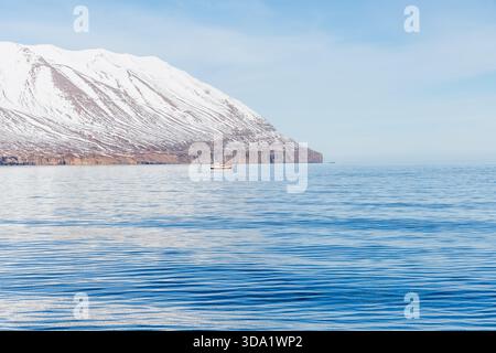 Una piccola barca sulle acque blu del fiordo di Eyjafjörður in una giornata di sole, l'Islanda Foto Stock