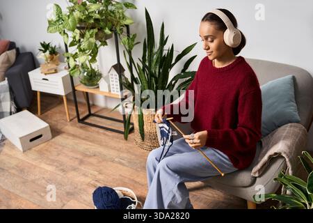 Una giovane donna afro-americana gode di un'intima maglia pomeridiana indossando un maglione marrone. Foto Stock