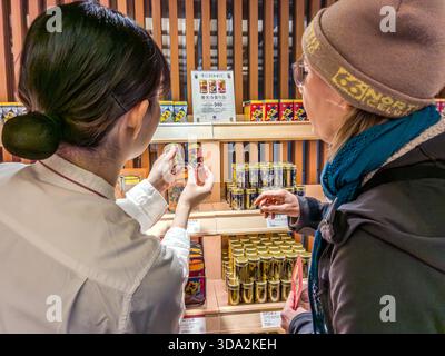 Presso il flagship store Yawataya Isogoro a Daimon-cho nella città di Nagano. La latta rossa e dorata, caratterizzata da un grande design a base di peperoncino e dal Tempio Zenkoji sul retro, è rimasta immutata per decenni. Nagano, Prefettura di Nagano, Giappone Foto Stock