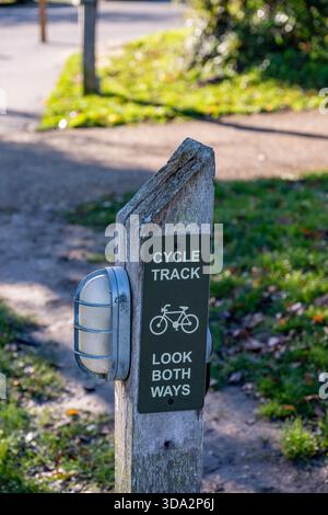 incrocio tra pista ciclabile e sentiero pubblico con cartello di avvertimento per i pedoni di guardare entrambi i lati prima di attraversare la pista ciclabile. Foto Stock