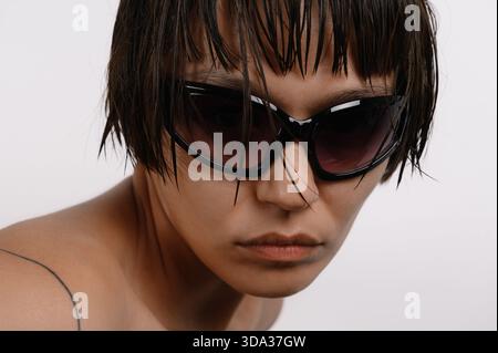 Primo piano di una donna cool con un corpetto e occhiali da sole eleganti Foto Stock