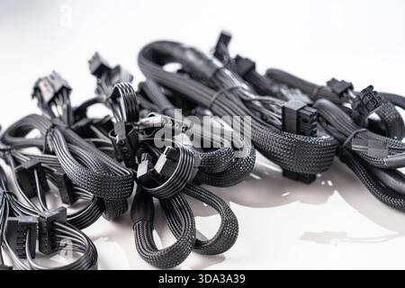 Assortimento di cavi neri per computer per alimentatori su sfondo bianco. Isolato Foto Stock