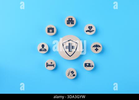 Concetto di assicurazione sanitaria e assistenza medica. Un insieme di blocchi di legno che mostrano icone relative alla salute, assistenza medica, assicurazione sanitaria e farmaci. Foto Stock