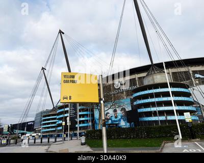 Manchester, Regno Unito - 16 novembre 2025: Palcoscenico luminoso con un cartello giallo per il parcheggio fuori da un moderno locale di Manchester, aspetto urbano. Foto Stock