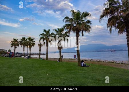 Relax al tramonto sul lungomare con palme e vista sulle montagne a Izmit, turchia Foto Stock