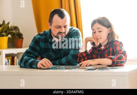 Padre e figlia fanno il puzzle a casa. Foto Stock