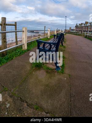 Panca in legno sul sentiero sulla scogliera di Cromer che si affaccia sulla spiaggia e sul mare. Visualizzazione ultra grandangolare Foto Stock