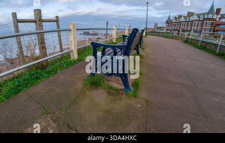 Panca in legno sul sentiero sulla scogliera di Cromer che si affaccia sulla spiaggia e sul mare. Visualizzazione ultra grandangolare Foto Stock