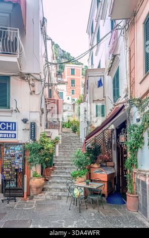 Stretti vicoli acciottolati con negozi e caffetterie e ristoranti sul marciapiede nel centro di Amalfi, nel sud Italia Foto Stock